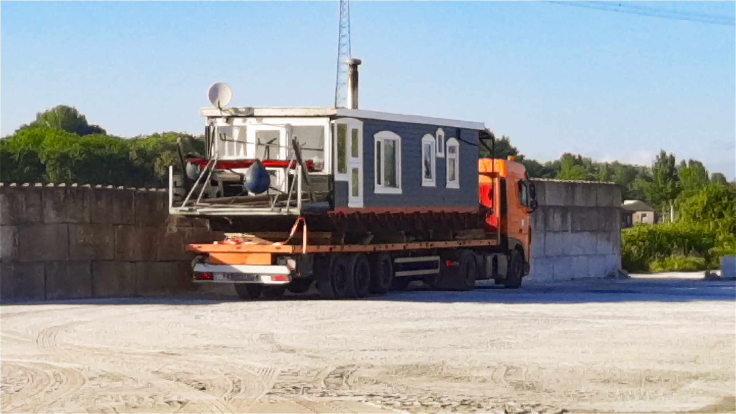 Ein Hausboot wird auf einem Tieflader der Firma Kröger GmbH in Großeheide zum neuen Standort tarnsportiert